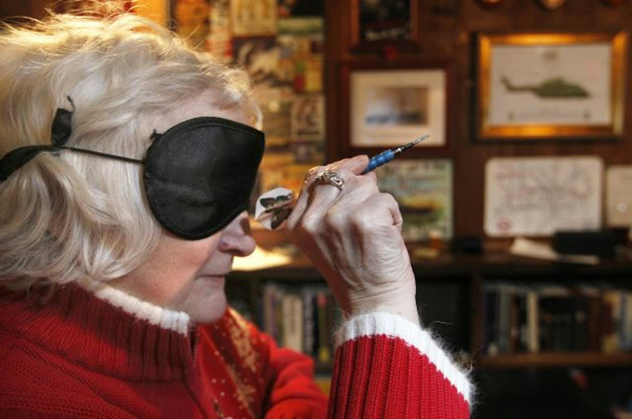 A blindfolded Diane Ruffcorn takes aim during an audio darts game at Merlin's Rest Pub in Minneapolis. Her league has a tournament this weekend.