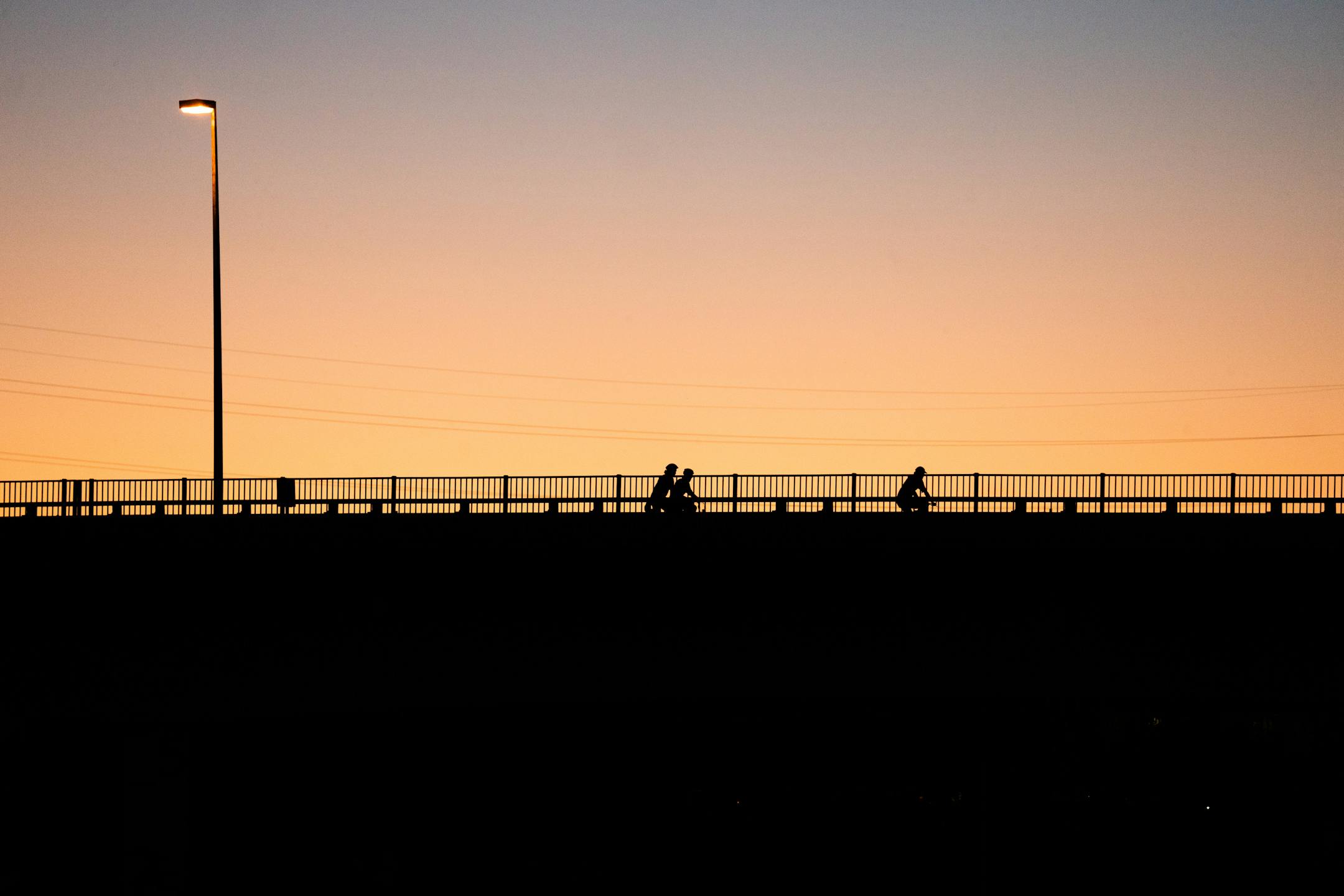 Bicyclists crossed the Plymouth Avenue bridge in Minneapolis at sunset.