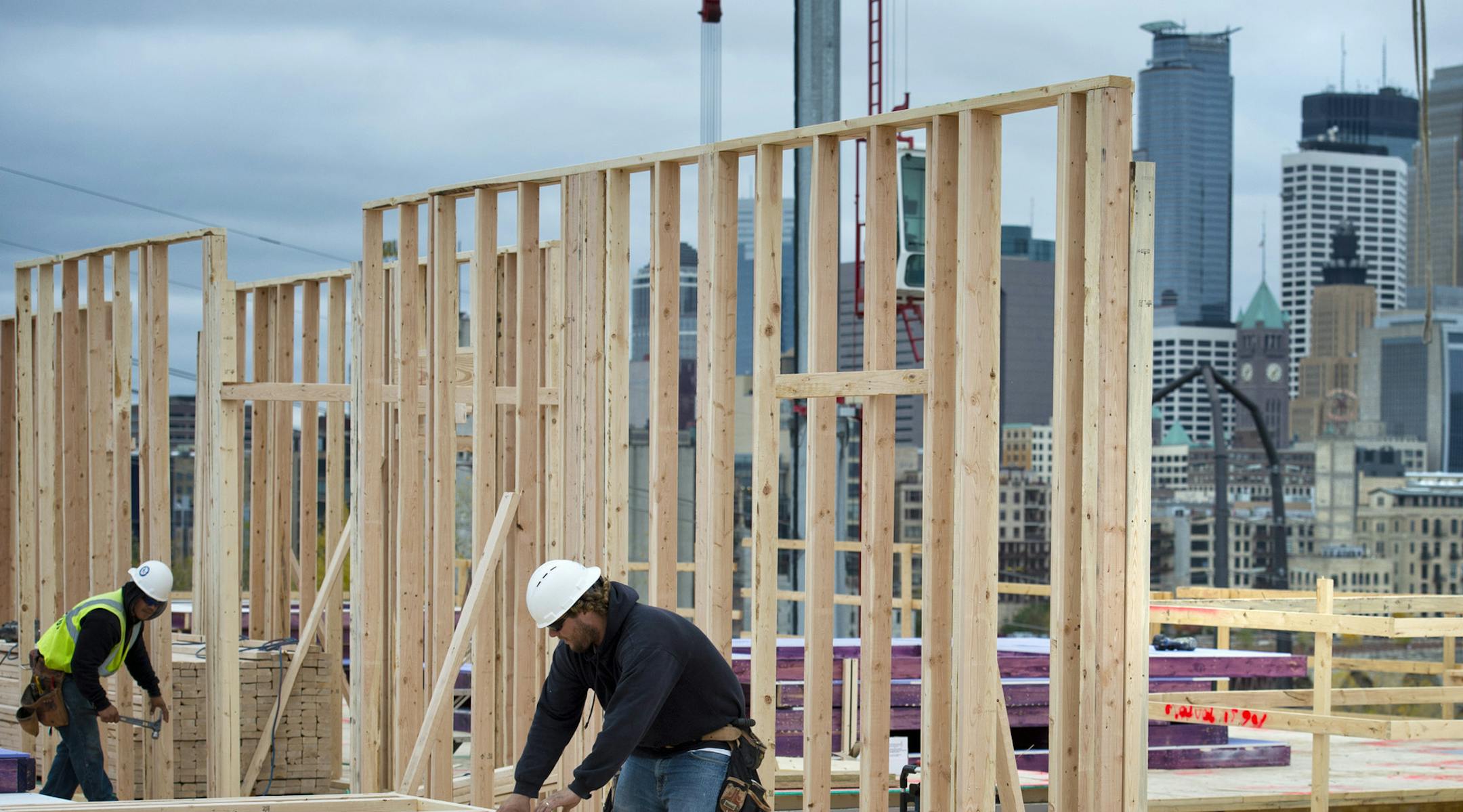 John Eitel and Luis Rodriguez put up wall frames at Mill and Main apartments, 501 Main St. SE. The Commerce Department said Wednesday that home construction rose 15 percent last month to a seasonally adjusted annual rate of 872,000. Apartment building increased 25.1 percent. Wednesday, October 17, 2012 ] GLEN STUBBE * gstubbe@startribune.com EDS: Eitel is wearing a blue jacket, no vest and rodriguez is wearing a yellow safety vest. ORG XMIT: MIN1210171648030928
