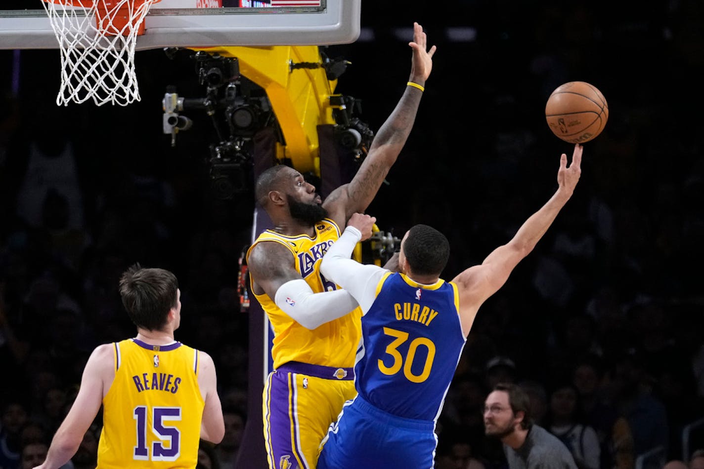 Golden State Warriors guard Stephen Curry, right, shoots as Los Angeles Lakers forward LeBron James, center, and guard Austin Reaves defend during the second half in Game 4 of an NBA basketball Western Conference semifinal Monday, May 8, 2023, in Los Angeles. (AP Photo/Marcio Jose Sanchez)