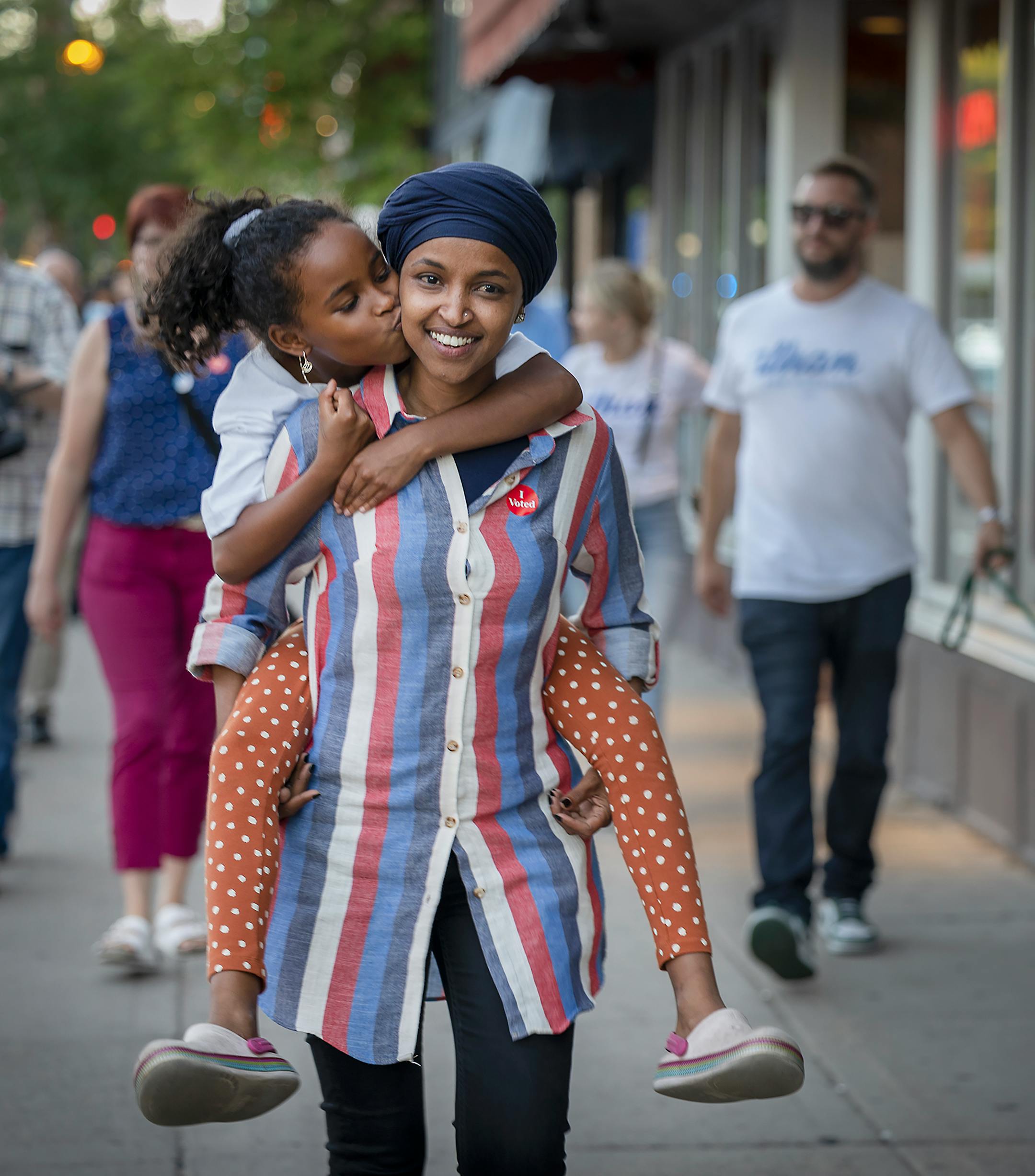 U.S. Rep. Ilhan Omar's youngest daughter Ilwad Hirsi, 10, gives her mom a kiss as she carries her for the last few minutes of open voting during a voter engagement event.