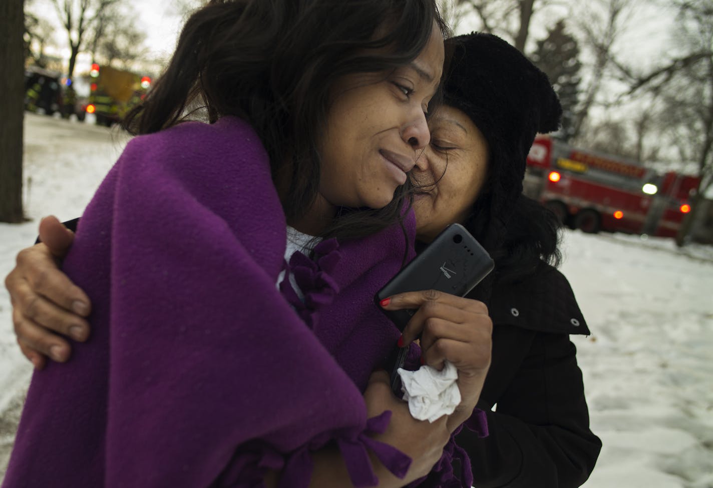 Zandrienne Hunt woke up to a fire at the unoccupied duplex next door on the 3100 block of Colfax Ave N in Minneapolis. The resulted damage to both units. Zandrienne Hunt who is being comforted by neighbor Melinee, last name withheld, lived there with her children and fiance. They lost their possessions to fire and water damage including the christmas presents.] Richard Tsong-Taatarii/rtsong-taatarii@startribune.com
