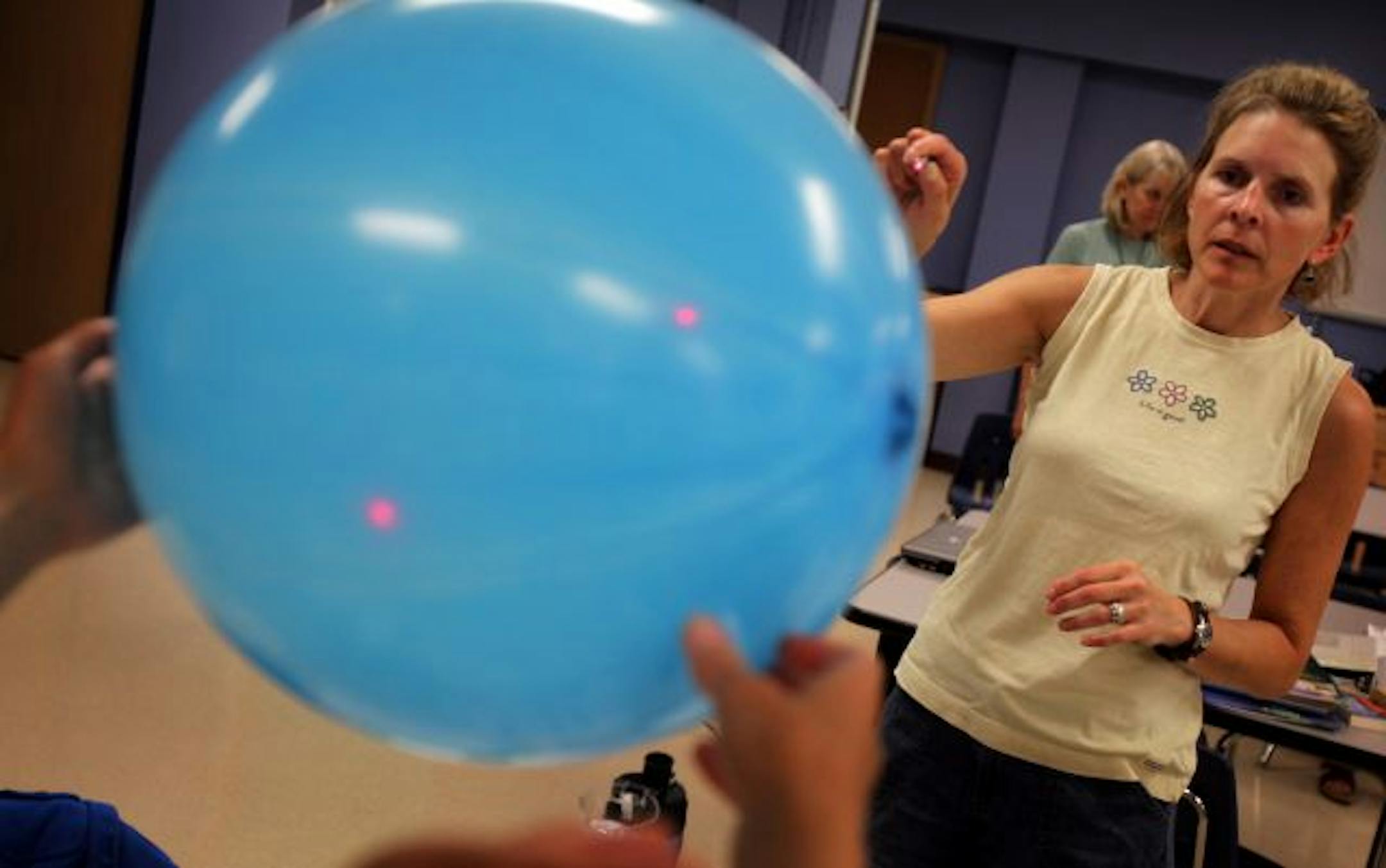 Sandy Stone projected a red light through a balloon during a science class. Like other teachers, she gave up a week of summer break for the training.