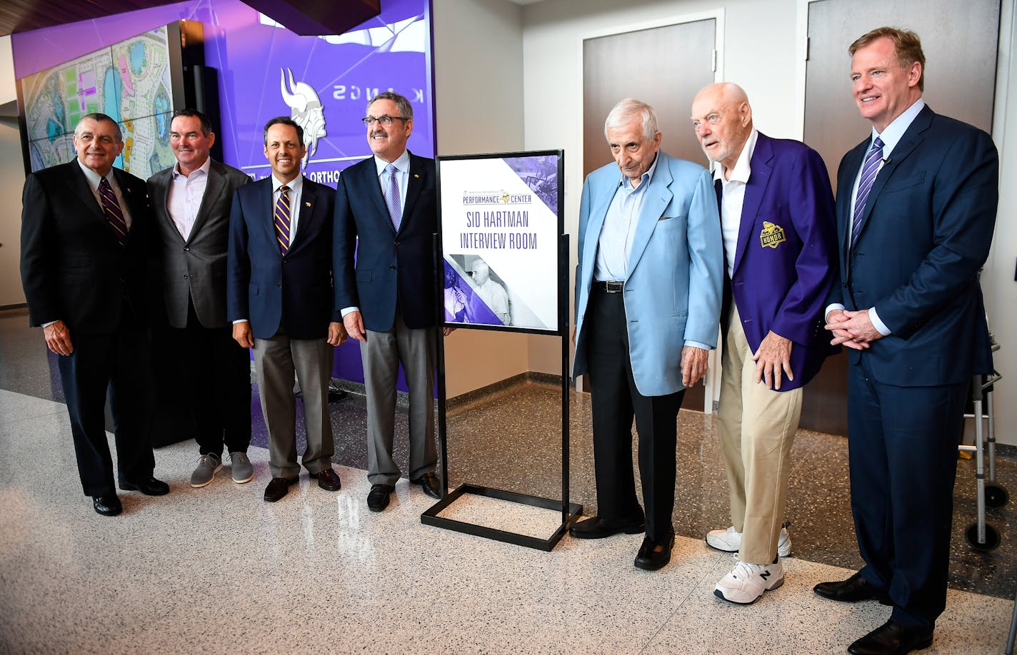 From left, Vikings co-owner Leonard Wilf, head coach Mike Zimmer, co-owners Mark and Zygi Wilf, columnist Sid Hartman, former Vikings coach Bud Grant and NFL Commissioner Roger Goodell, stood for a photo in front of the entrance of the Sid Hartman Interview Room Friday during its unveiling. ] AARON LAVINSKY &#xef; aaron.lavinsky@startribune.com The Sid Hartman Interview Room was unveiled Friday, June 15, 2018 at the Vikings new training facility in Eagan, Minn. Remarks were made by NFL Commissio