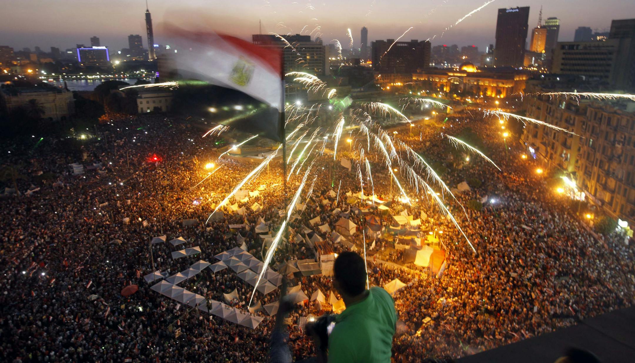 An Egyptian protester waves a national flag as Egyptians gather in Tahrir Square during a demonstration against President Mohammed Morsi in Cairo, Sunday.