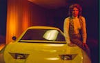 Elizabeth Carmichael posing next to the Dale Automobile.