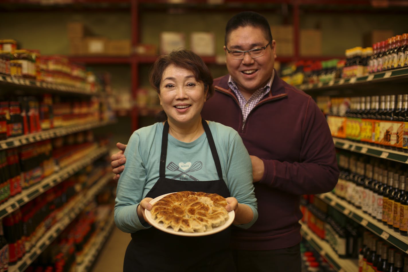 Alice Fung and her son, Eric, with a plate of Chinese potstickers she cooked up at United Noodles Wednesday afternoon.