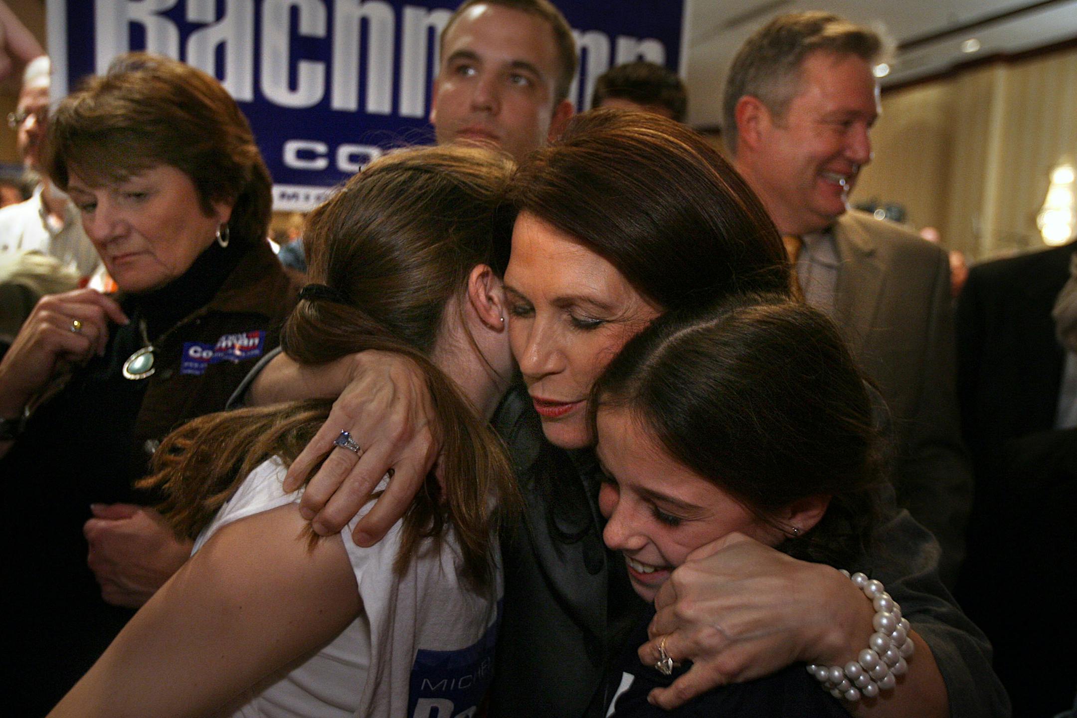 Michele Bachmann embraced Lexi, 11, and Cali Weddle, 9, of Andover. Bachmann's husband, Marcus, is at right at the Bloomington Sheraton GOP gathering.