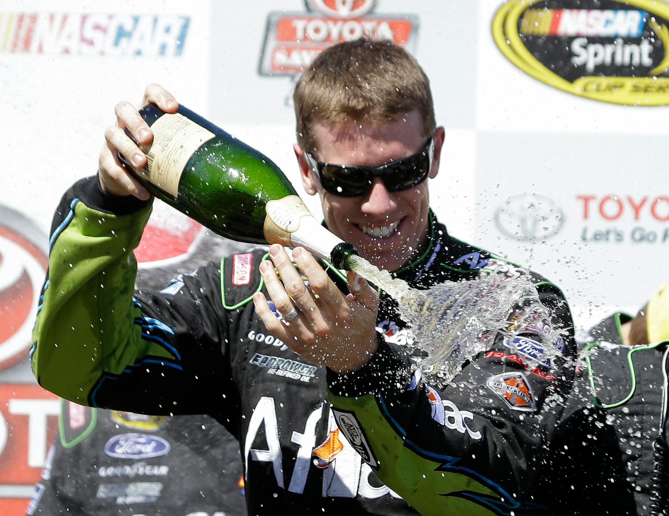 Carl Edwards sprays sparkling wine after winning the NASCAR Sprint Cup Series race Sunday, June 22, 2014, in Sonoma, Calif.