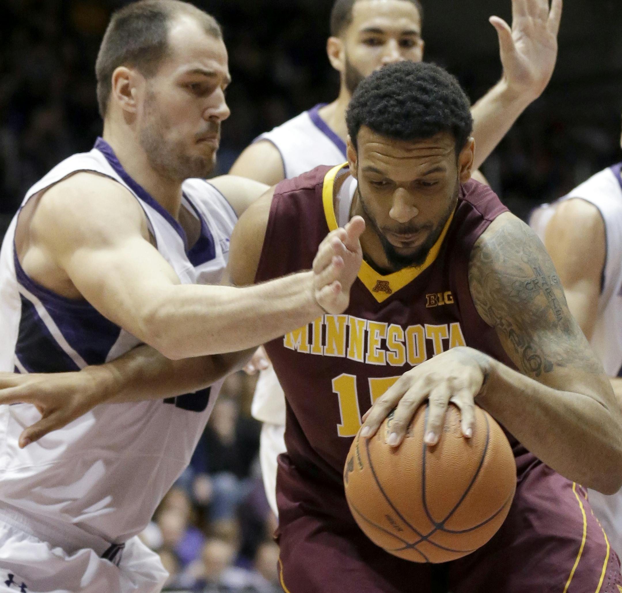 Minnesota forward Maurice Walker, right, controls the ball against Northwestern's Nikola Cerina, left, Drew Crawford, top, and Tre Demps during the first half of an NCAA college basketball game in Evanston, Ill., Sunday, Feb. 16, 2014. (AP Photo/Nam Y. Huh)