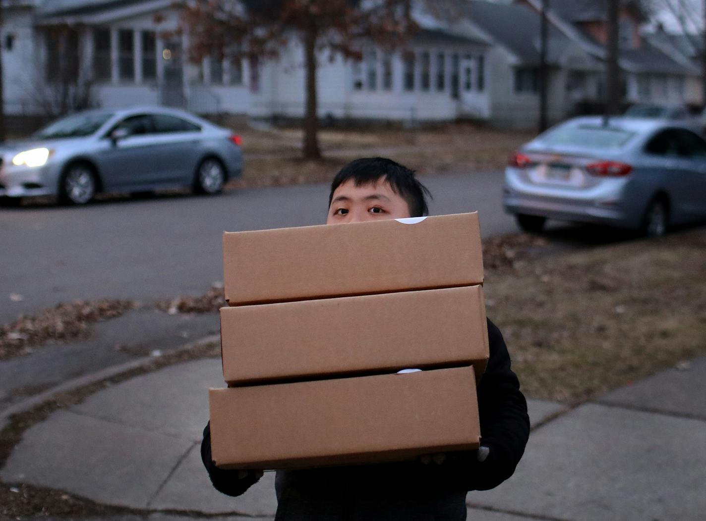 **EDITOR'S NOTE: PLEASE DO NOT LIGHTEN FACES SO ID'S OF MEAL RECIPIENTS ARE NOT REVEALED, POTENTIALLY CAUSING EMBARRASSMENT** St. Paul school bus drivers and aides headed out a week's worth of breakfasts and lunches to families of students along their route Wednesday, March 25, 2020, in St. Paul, MN. Here, a young student with meals for him and his siblings, handed out along the route.] DAVID JOLES &#x2022; david.joles@startribune.com We ridealong with a St. Paul school bus as it delivers a week