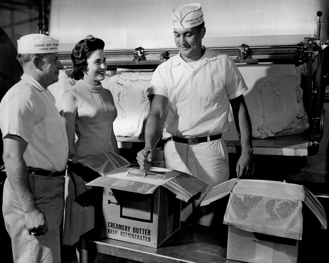 A buttermaker at Goodhue Co-op Creamery, right, packs butter for shipping alongside his manager and Minnesota's Princess Kay of the Milky Way in 1962.