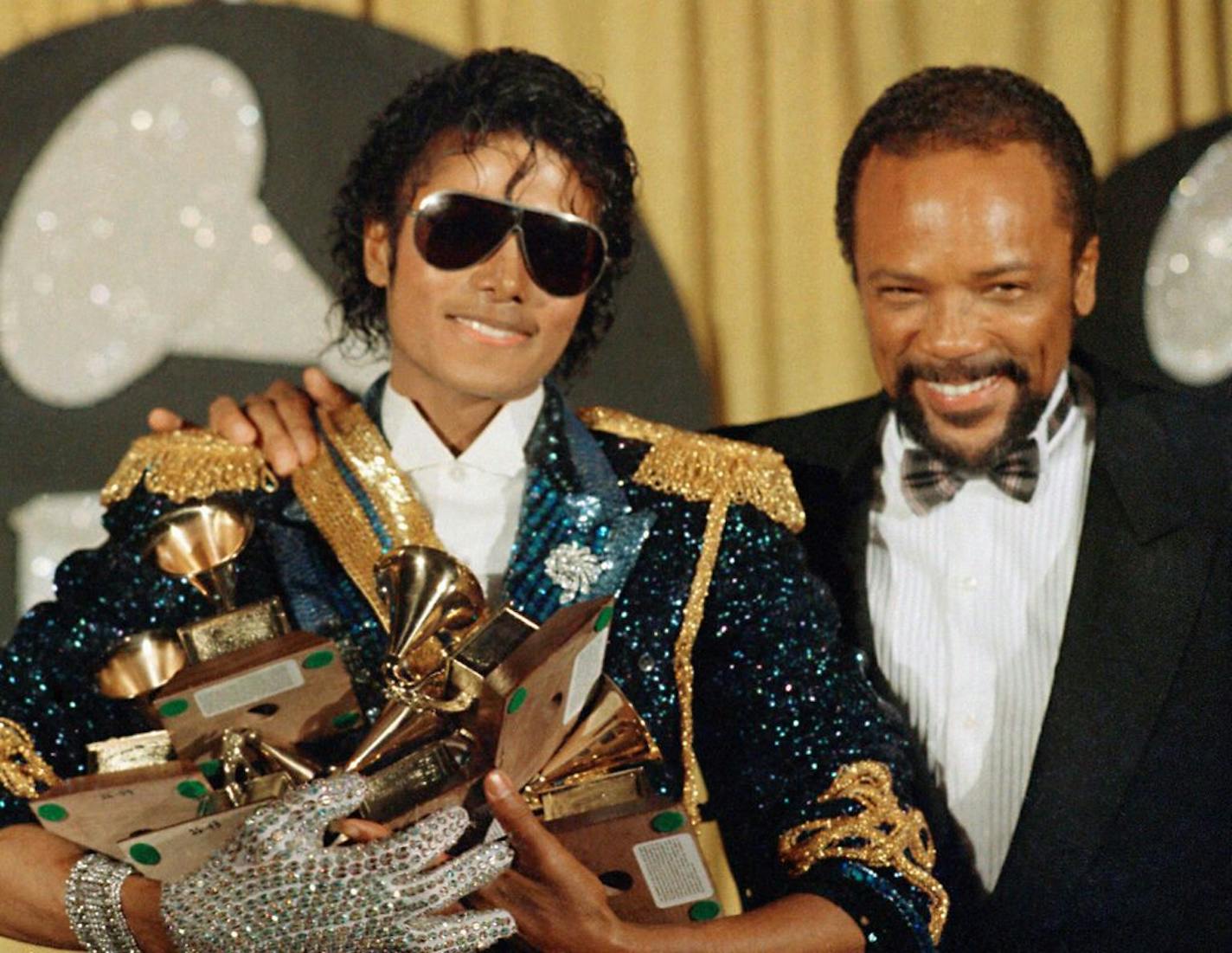 FILE - In this Feb. 28, 1984, file photo, Michael Jackson, left, holds eight awards as he poses with Quincy Jones at the Grammy Awards in Los Angeles. Jackson's estate announced Aug. 7, 2017, that a 3-D version of his iconic "Thriller" video will debut at the Venice Film Festival, which begins Aug. 30.