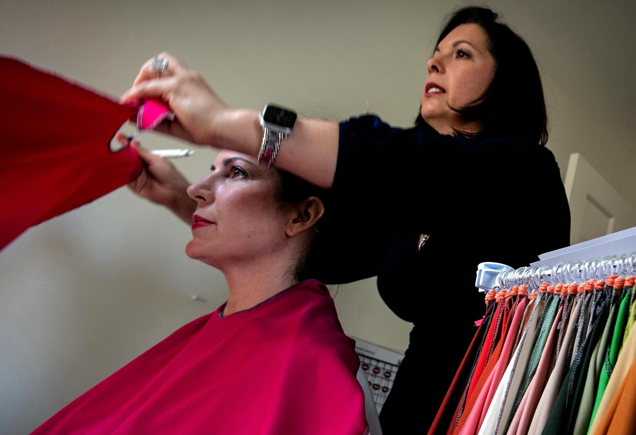 Melany Carlos, an Arlington, Va., image consultant specializing in seasonal color analysis, drapes various colorful cloths over client Juli Stott. MUST CREDIT: Washington Post photo by Bill O'Leary