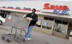 In this April 12, 2011 photo, shopper Andrew Boston leaves the Save-a-Lot grocery store with his purchases in Northfield, Ohio. Grocer Supervalu Inc.'