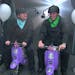 James Corden, left, and Matt LeBlanc race each other on scooters.