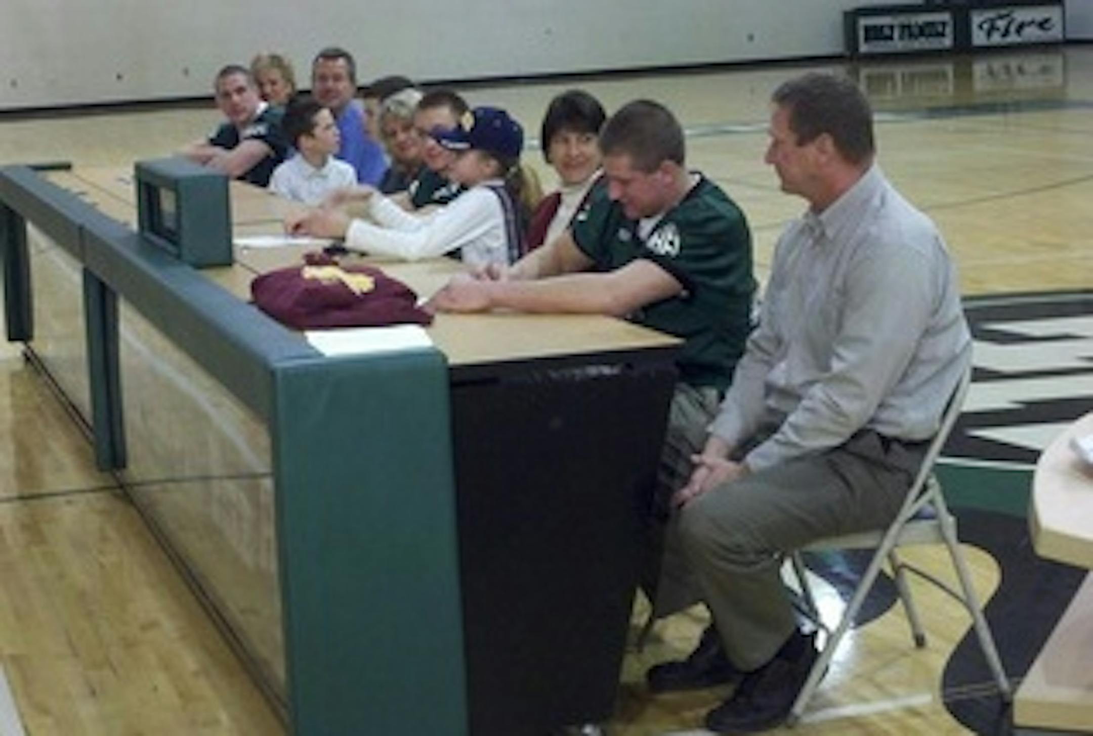 Peter Westerhaus (second from right) signs on the dotted line to play for the Gophers