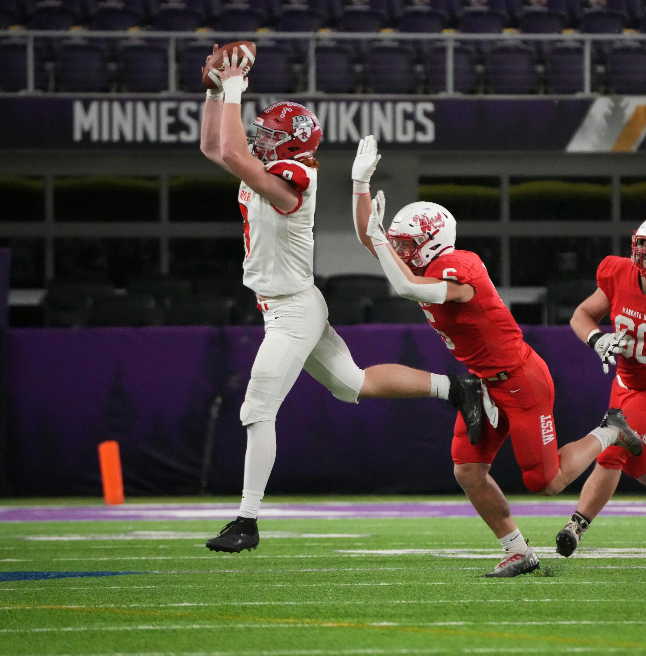 Elk River's Jack Lachmiller (9) reaches for a pass while defended by Mankato West's Ethan Bartell (6) to get a first down in the second half of the Minnesota High School football Class 5A State Championship at U.S. Bank Stadium in Minneapolis, Minn., on Saturday, Dec. 3, 2022.