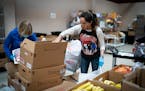 Volunteer Becky Geyer, of Edina, filled boxes of food as she volunteered with her mother Diane Haider, of Lake Elmo, left, at the Twin Cities Salvatio