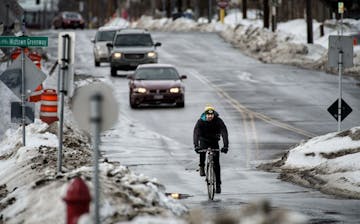 Bicyclists ride along 28th Street E where it intersects with the Midtown Greenway in Minneapolis,Tuesday, February 18, 2014