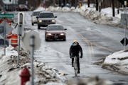 Bicyclists ride along 28th Street E where it intersects with the Midtown Greenway in Minneapolis,Tuesday, February 18, 2014