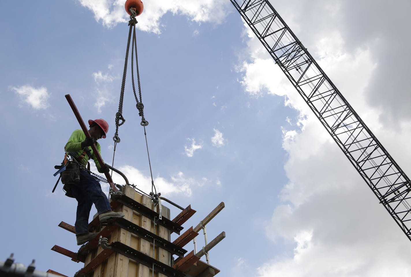 FILE- In this June 20, 2018 photo, a member of a construction team works on the site of Gables Station, a mixed use project featuring apartments, retail, a hotel and cafes, in Coral Gables, Fla. Most U.S. business economists expect corporate sales to grow over the next three months and hiring and pay to rise with them. Goods producers &#x2014; a category that includes manufacturers, farmers and construction &#x2014; are most optimistic, with 94 percent saying they expect sales to rise over the n