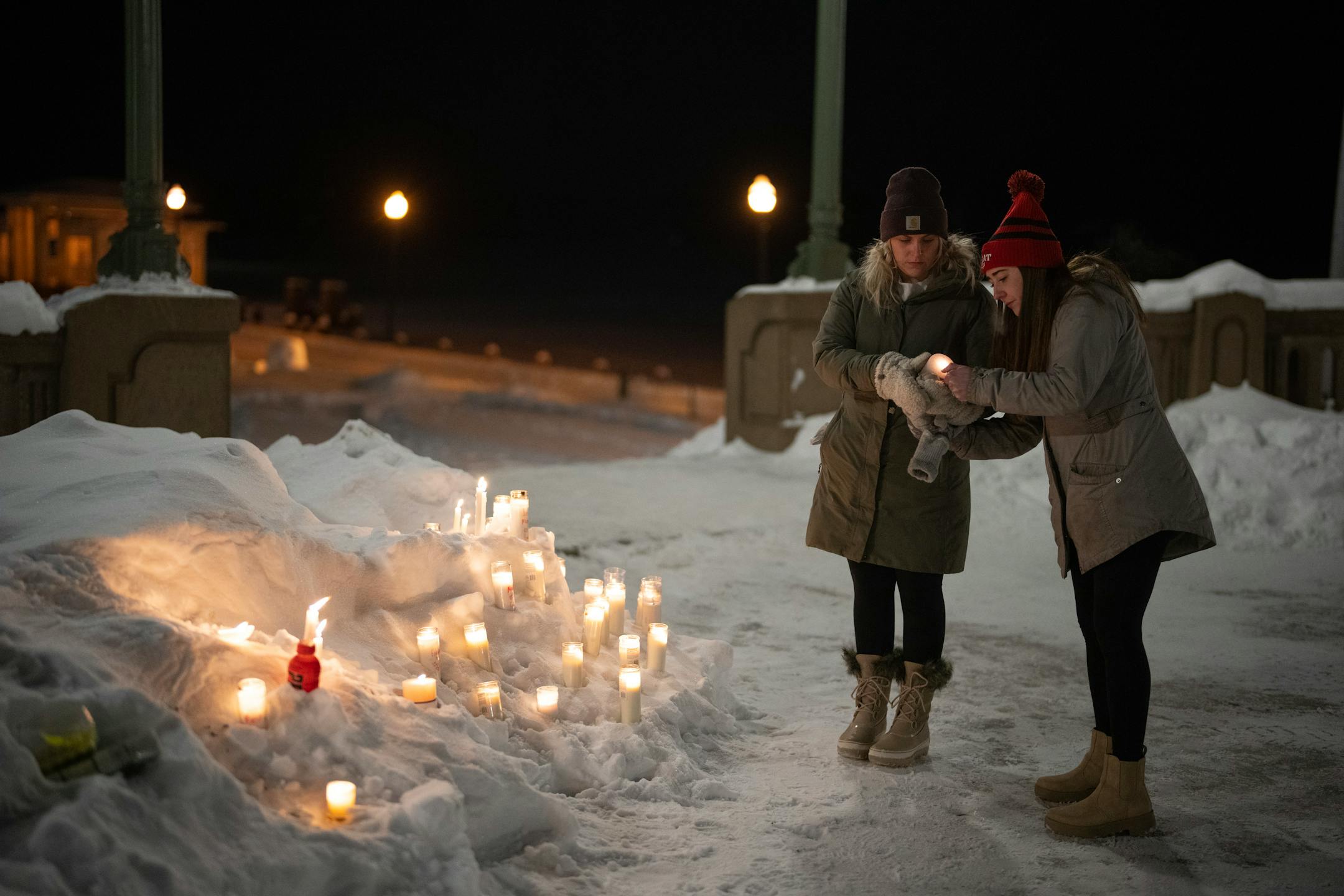 Mourners left candles burning in a snowbank after the vigil.