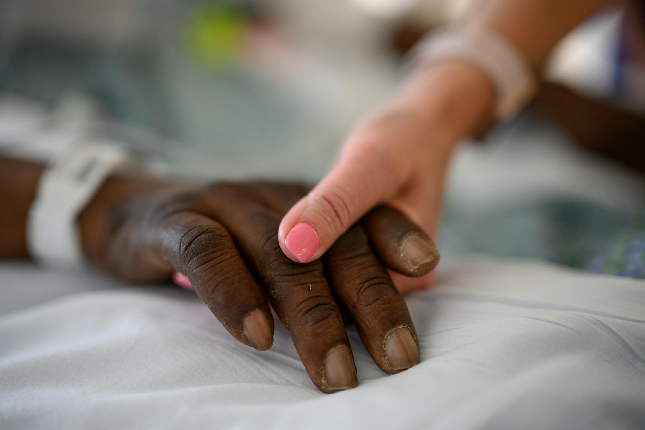 Critical care nurse Amy Berwald held the hand of an intubated COVID patient Tuesday, Feb. 8, 2022 at North Memorial Health Hospital's South 7 Intensive Care Unit in Robbinsdale, Minn.