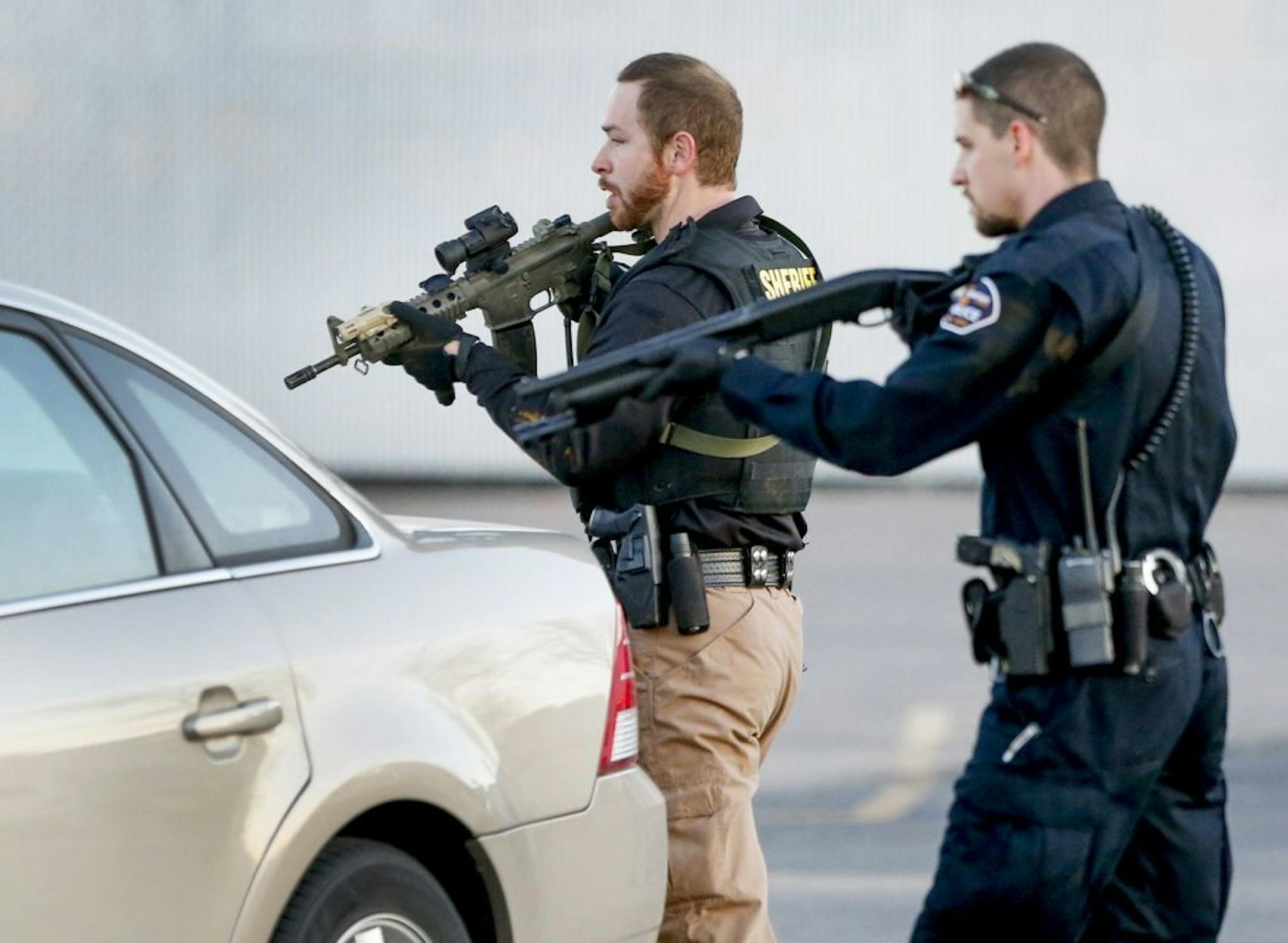 Police go through the parking lot of Excel Industries in Hesston, Kan., where a gunman reportedly killed up to seven people and injured many others on Thursday, Feb. 25, 2016.