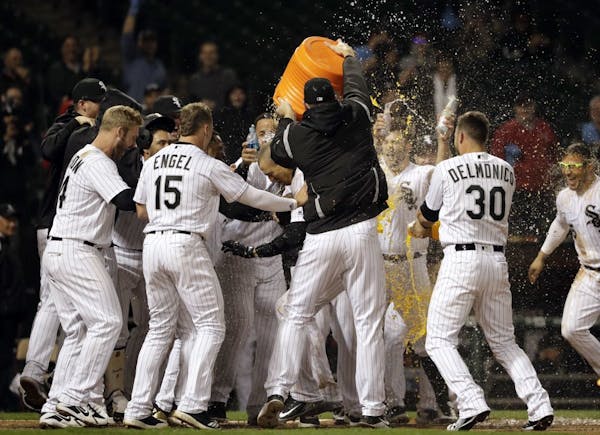 Chicago White Sox's Trayce Thompson, center, is congratulated by teammates after hitting the game-winning solo home run against the Minnesota Twins in
