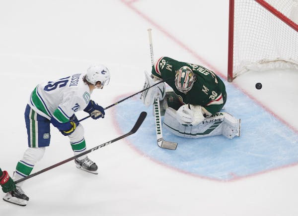 Wild goalie Alex Stalock (32) is scored on by Vancouver Canucks' Antoine Roussel (26) during the third period