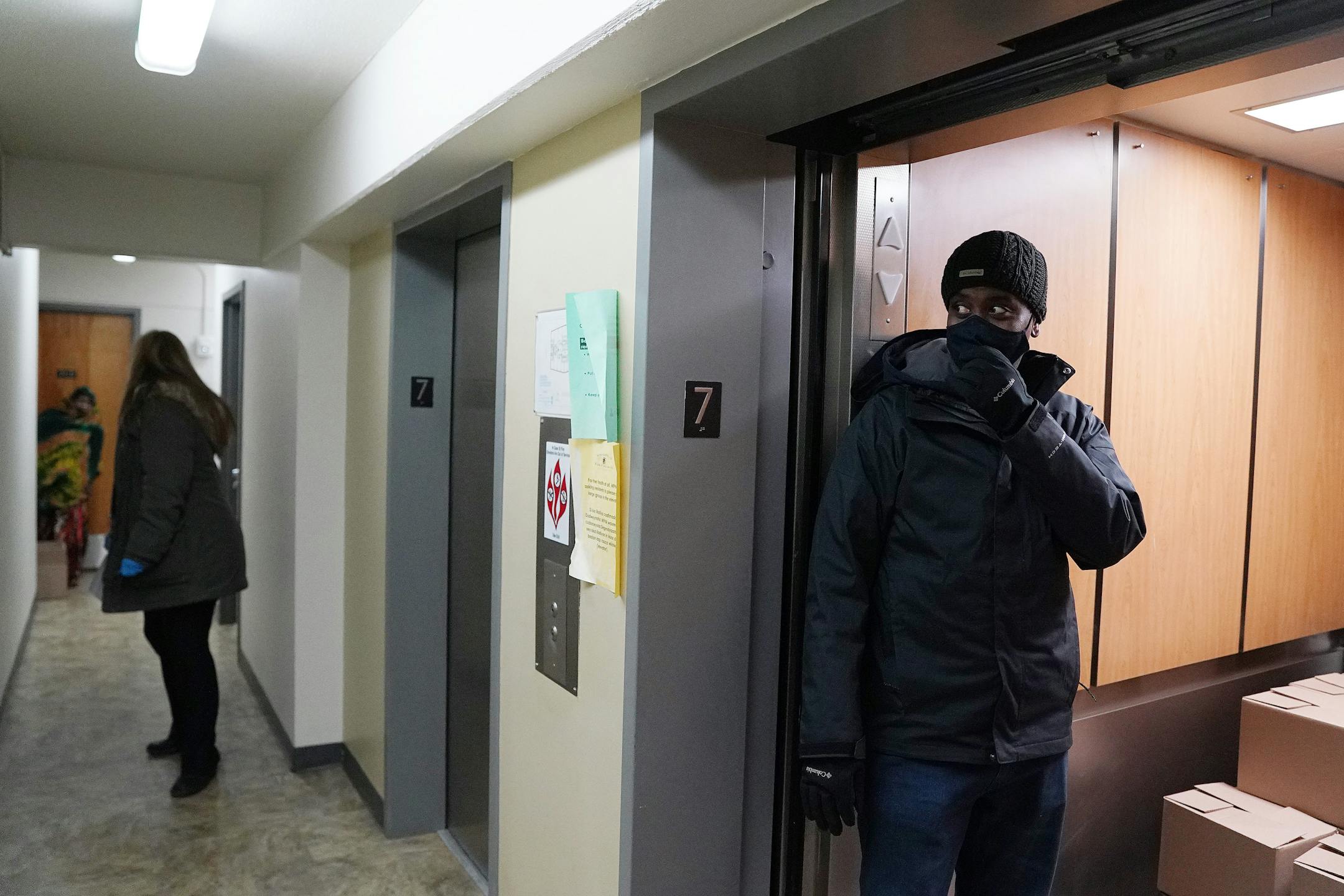 Minneapolis Public Housing Authority executive director Abdi Warsame, right, helped Loni Erbstoesser, center, deliver boxes of food from East Side Neighborhood Services to residents at the Hiawatha Towers Wednesday. ] ANTHONY SOUFFLE • anthony.souffle@startribune.com
