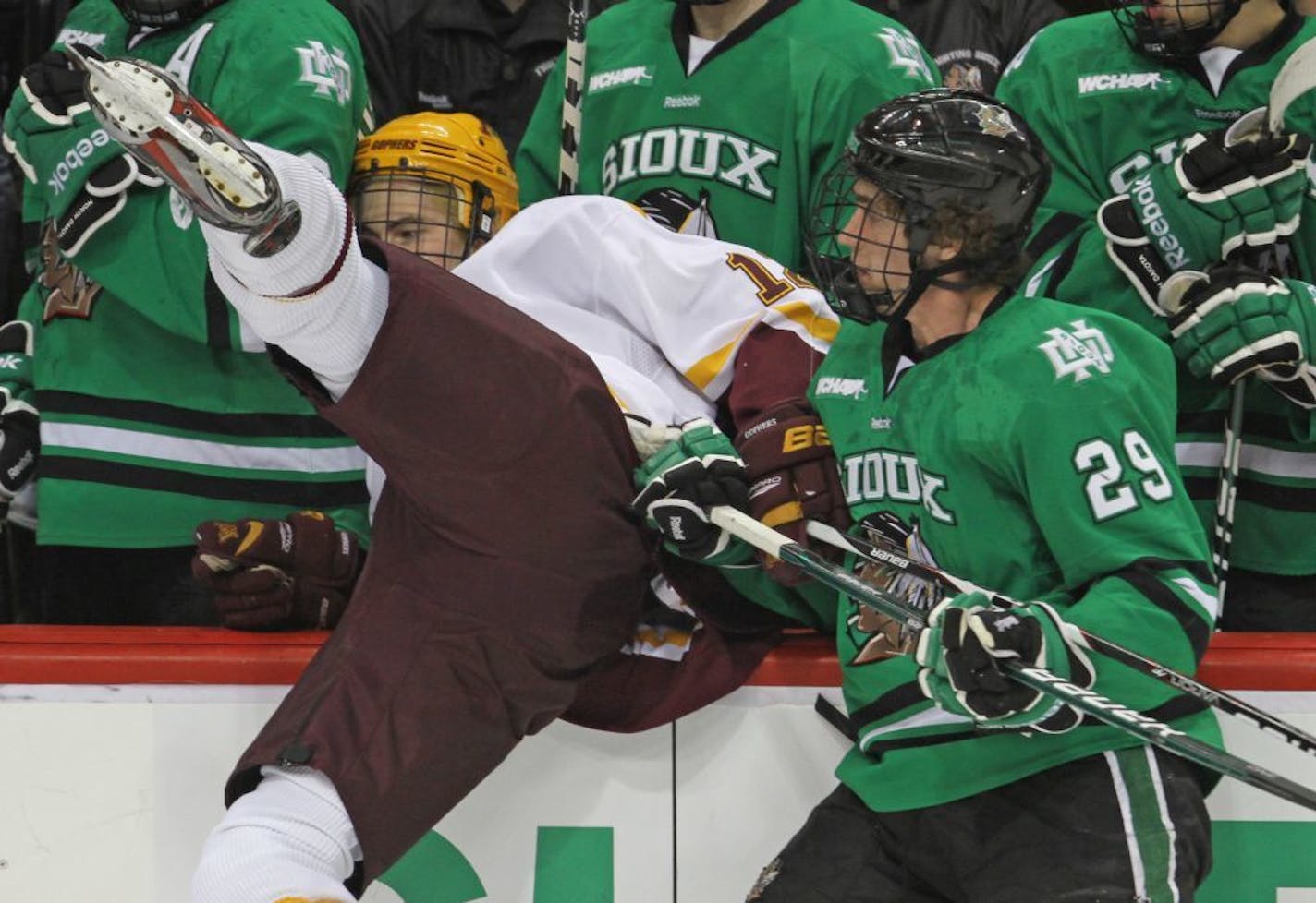 WCHA Frozen Five Semi-Finals in 2012: University of Minnesota vs. North Dakota, Xcel Center, 3/16/12. (left to right) Minnesota's Justin Holl was checked into the Sioux bench by North Dakota's Brock Nelson.