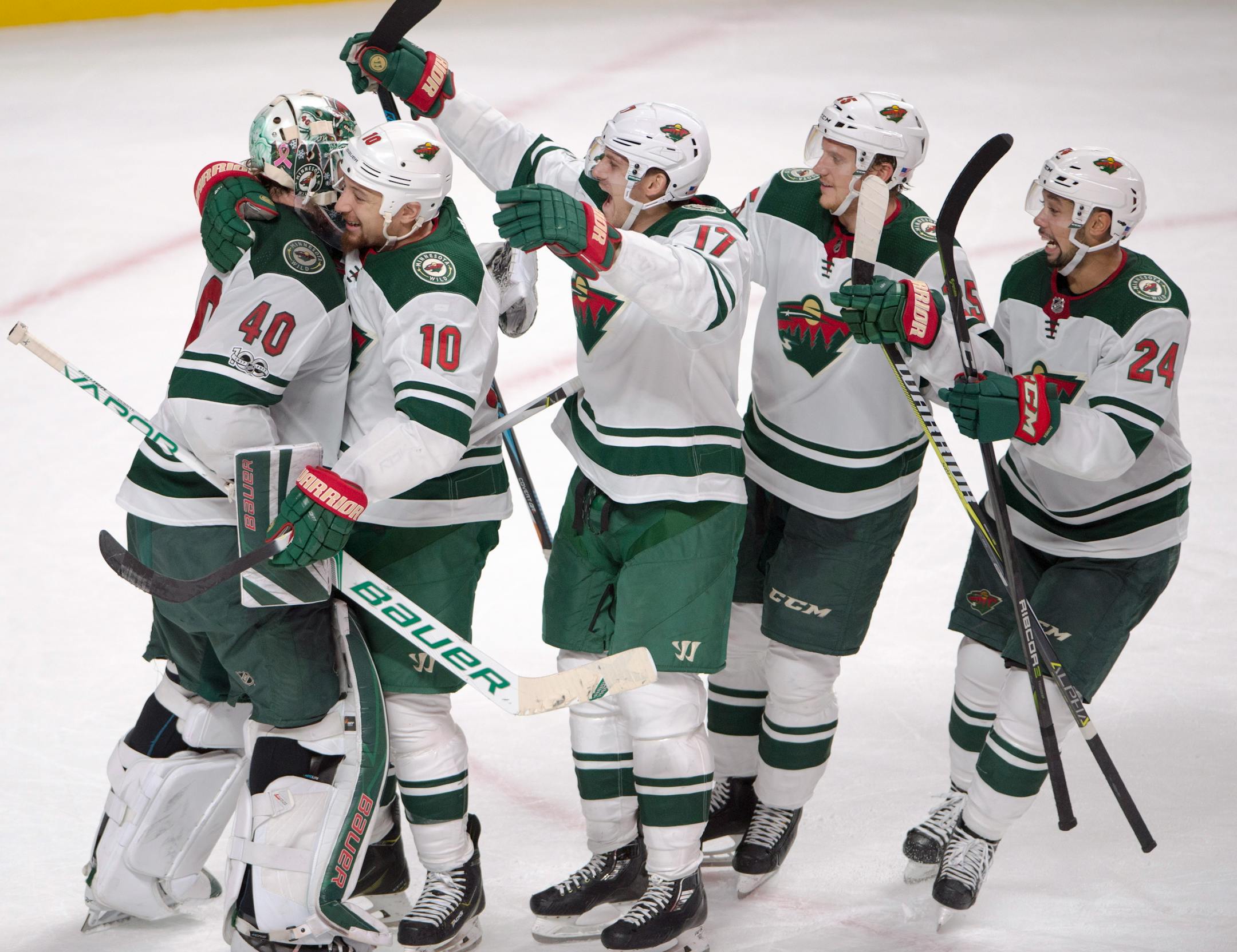 Minnesota Wild goalie Devan Dubnyk (40) celebrates with teammates Chris Stewart (10), Marcus Foligno (17), Jonas Brodin (25) and Matt Dumba (24)