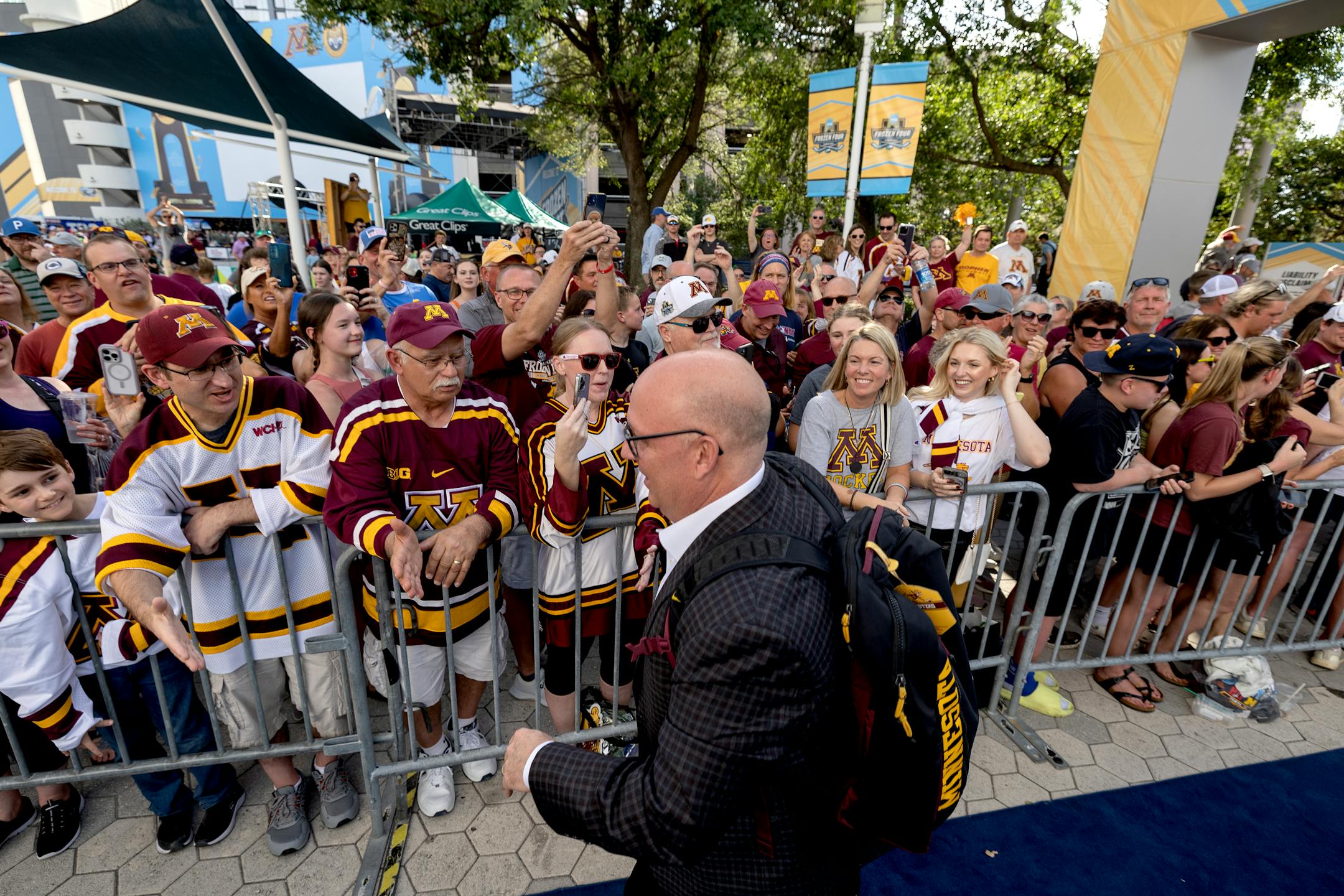 Minnesota head coach Bob Motzko is greeted by fans as the team arrives.