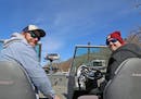 Jake Wallner, left, of St. Paul and his buddy Adam Bergstrom of Farmington, both 28, set off on the MIsssissippi River Tuesday in Bergstrom's new boat