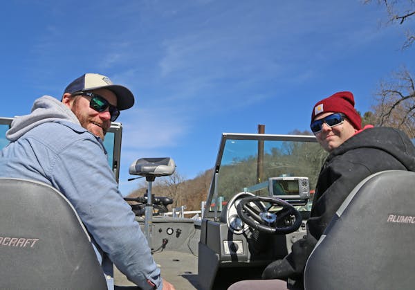 Jake Wallner, left, of St. Paul and his buddy Adam Bergstrom of Farmington, both 28, set off on the MIsssissippi River Tuesday in Bergstrom's new boat