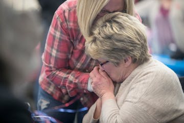 Photo by Elizabeth Flores: Longtime Minneapolis City Council Member Barb Johnson gave her sister, Therese VanBlarcom, a kiss on the hand after the fir