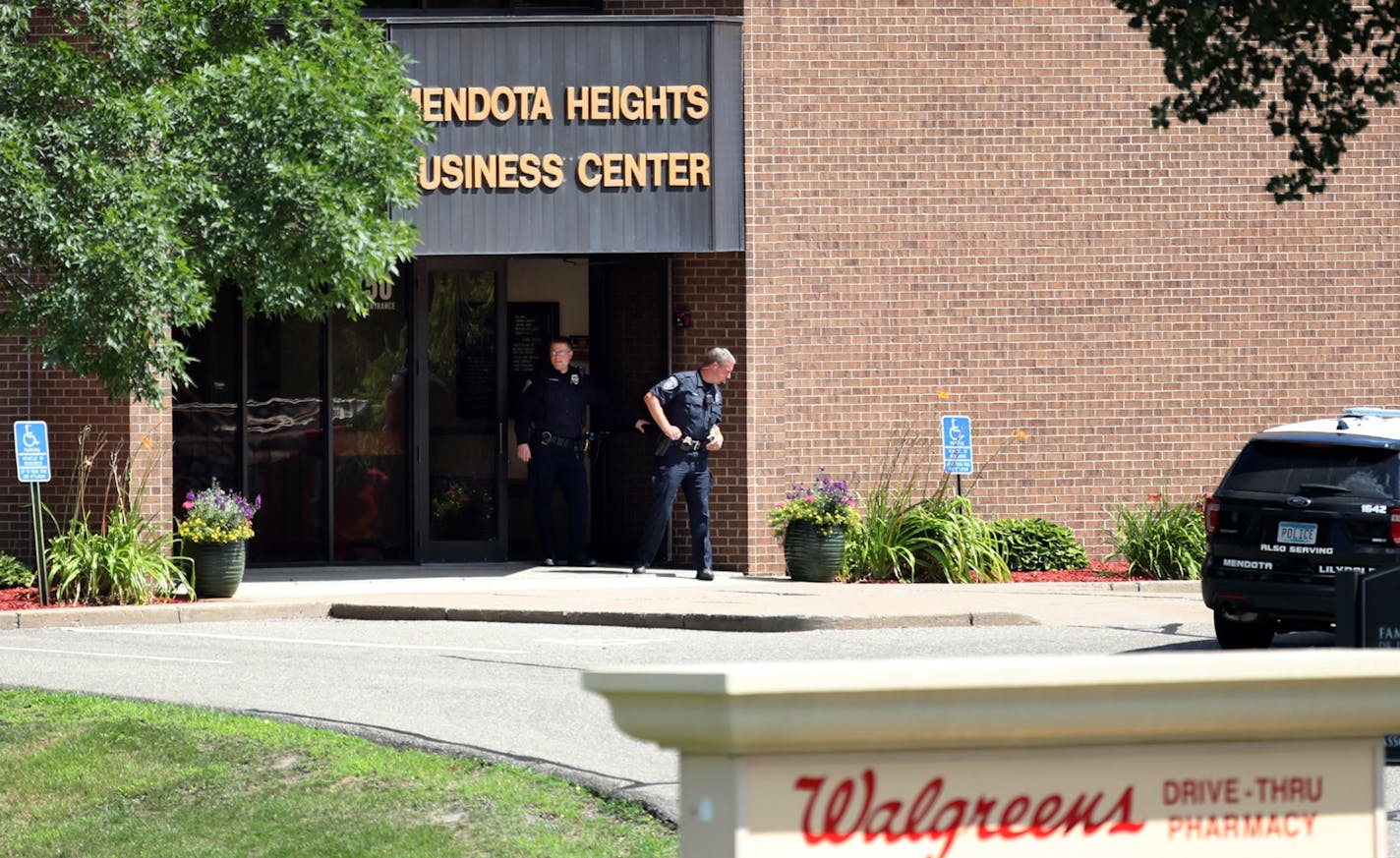 Police stand outside the Mendota Heights Business Center, where a woman's body was found Saturday during a search for an alleged armed robbery suspect.