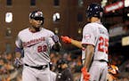 Minnesota Twins' Miguel Sano, left, fist-bumps teammate Byron Buxton after scoring on a bases-loaded walk to Eduardo Nunez during the fourth inning of