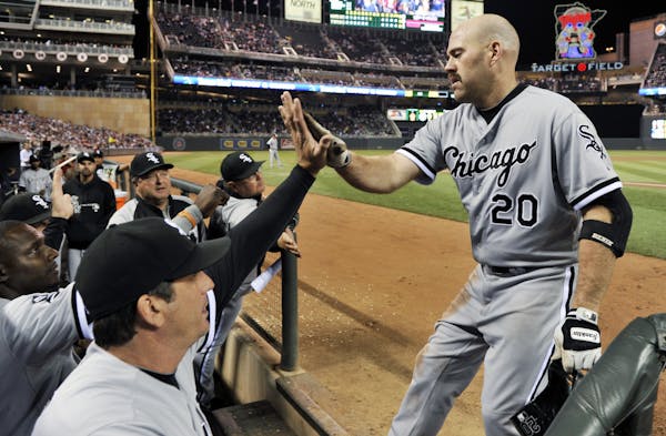 Chicago White Sox's Kevin Youkilis, right, is congratulated in the dugout after his solo home run off Minnesota Twins' Kyle Waldrop in the seventh inn