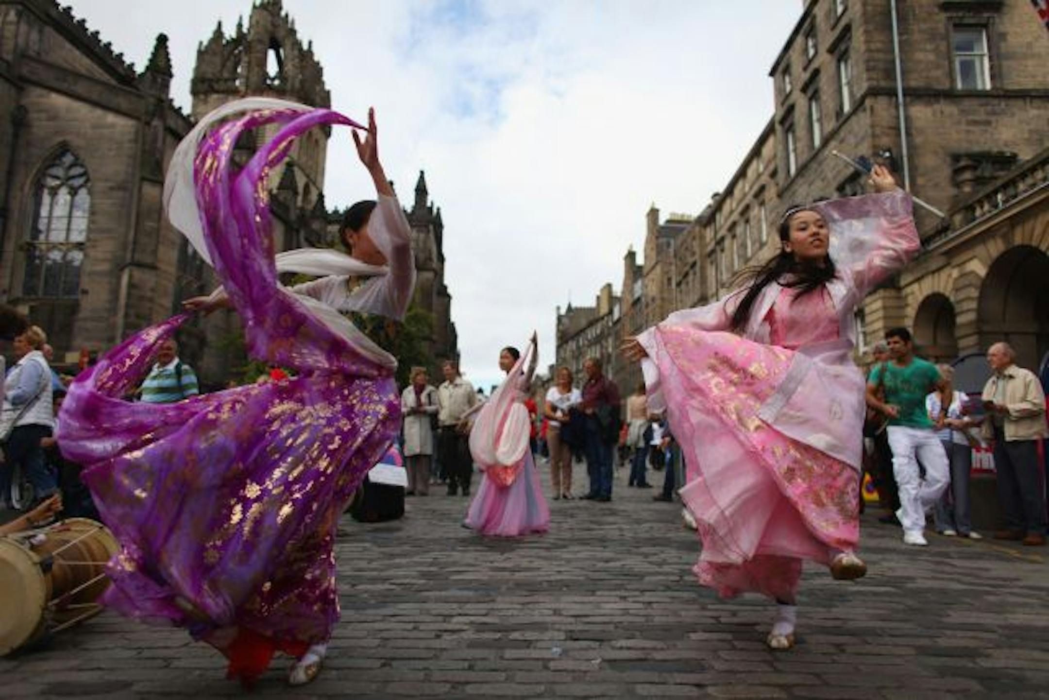 Performers whirl along Edinburgh's pedestrian-only Royal Mile to promote their shows in the Festival Fringe, which was established as an alternative to the International Festival also held each August.