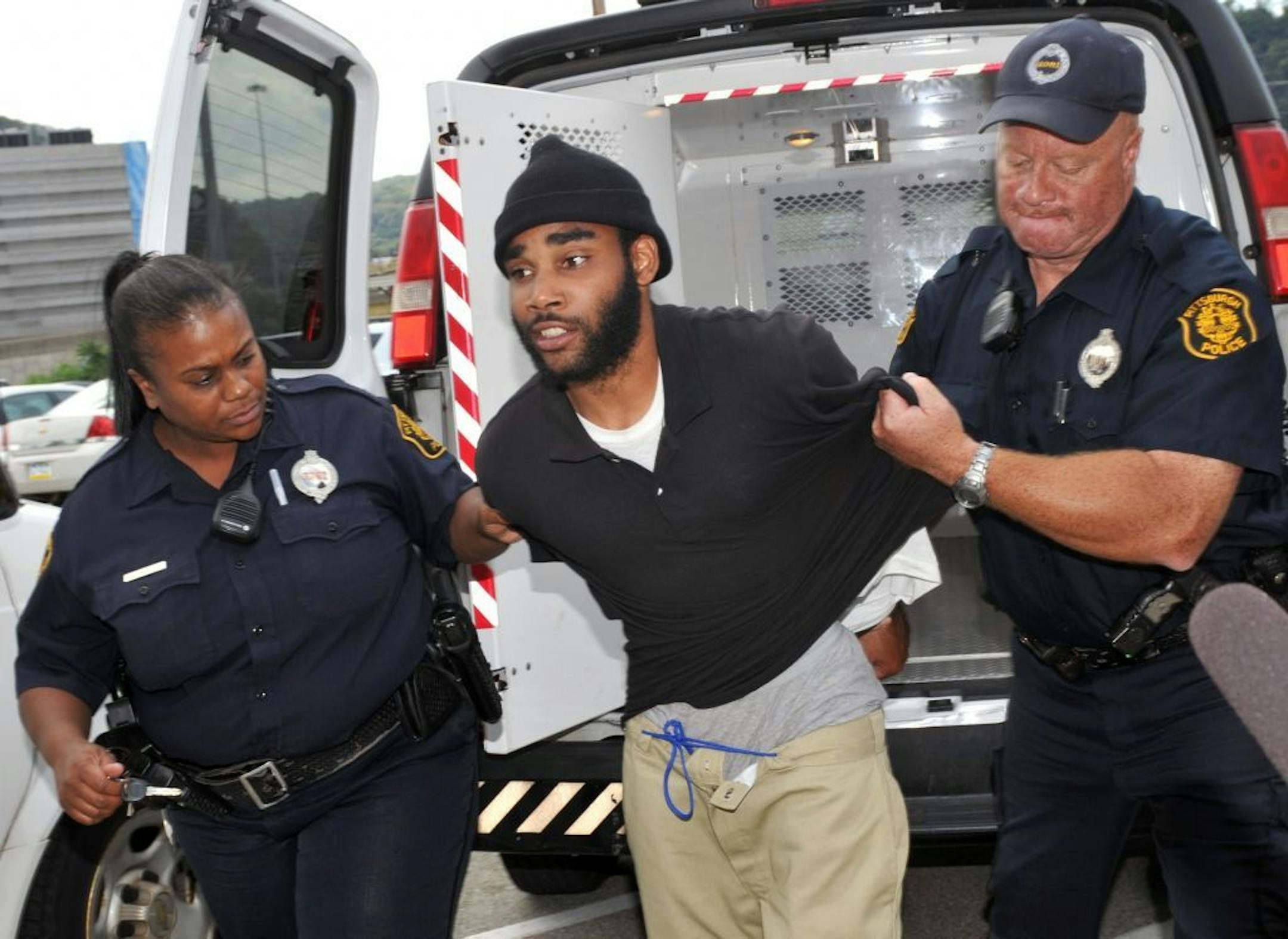 Klein Michael Thaxton, center, is lead into Pittsburgh Police headquarters after being apprehended without incident at Three Gateway Center in Pittsburgh, Friday Sept. 21, 2012. Thaxton held a businessman hostage inside the office building for more than five hours Friday, posting Facebook updates during the standoff, and surrendered to authorities without incident, police said. (AP Photo/The Tribune-Review, JC Schisler) PITTSBURGH OUT
