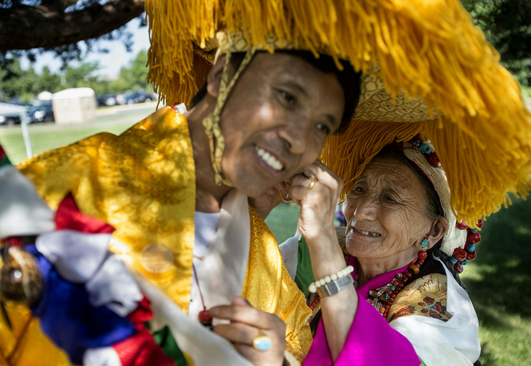 An elder in the community helps a younger dancer with his headwear before the procession. ] ALEX KORMANN • alex.kormann@startribune.com July 6, 2018 marked the 83rd birthday of the 14th Dalai Lama, the spiritual leader of Tibetan Buddhism. On July 7th, Tibetan communities from around the metro area came together at Boom Island Park to celebrate his birthday with traditional dances and prayers. Performers dressed in traditional garments and performed in a procession before monks led the co