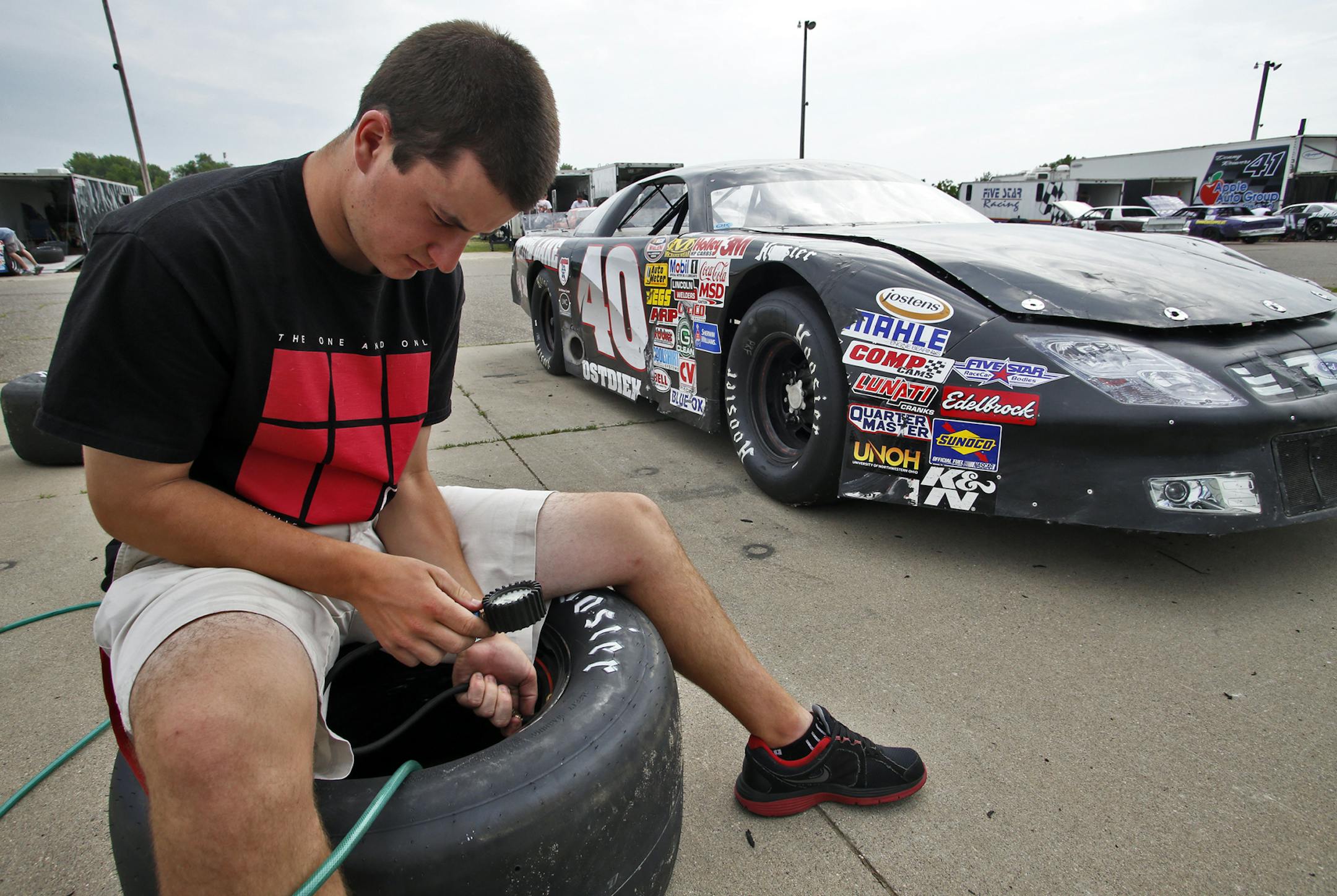 Matthew Ostdiek checked the inflation level of one of his racing tires.