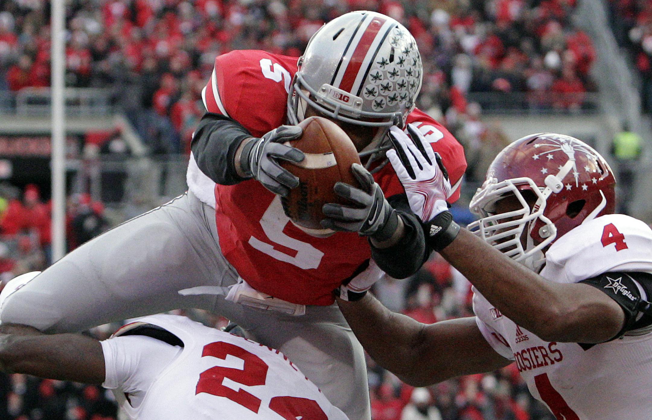 Ohio State quarterback Braxton Miller, top, scores a touchdown against Indiana's Tim Bennett, left, and Forisse Hardin during the second quarter of an NCAA college football game Saturday, Nov. 23, 2013, in Columbus, Ohio. (AP Photo/Jay LaPrete)