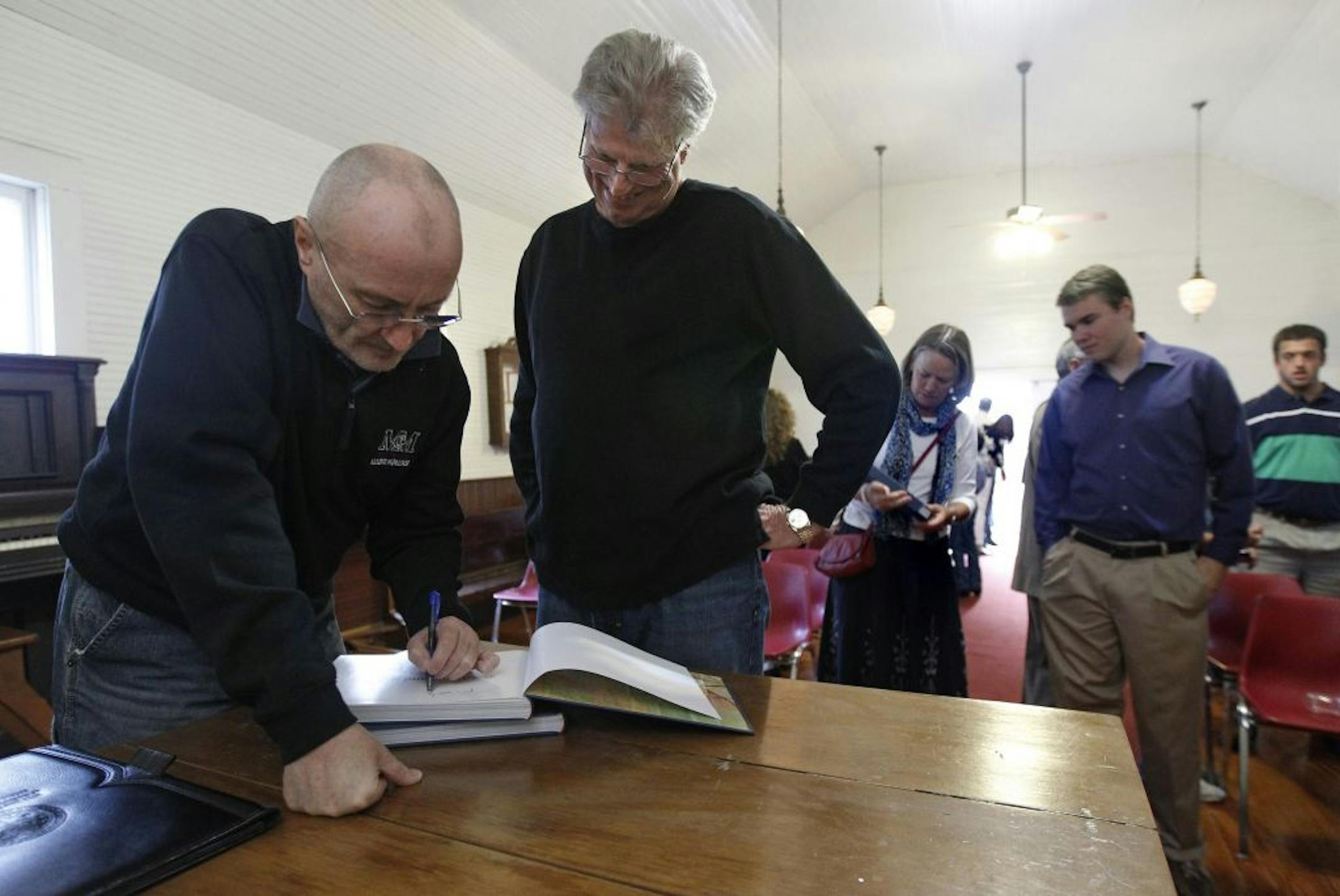McMurry College football coach Hal Mumme gets musician Phil Coillins to sign copies of his book on the Alamo in Buffalo Gap, Texas.