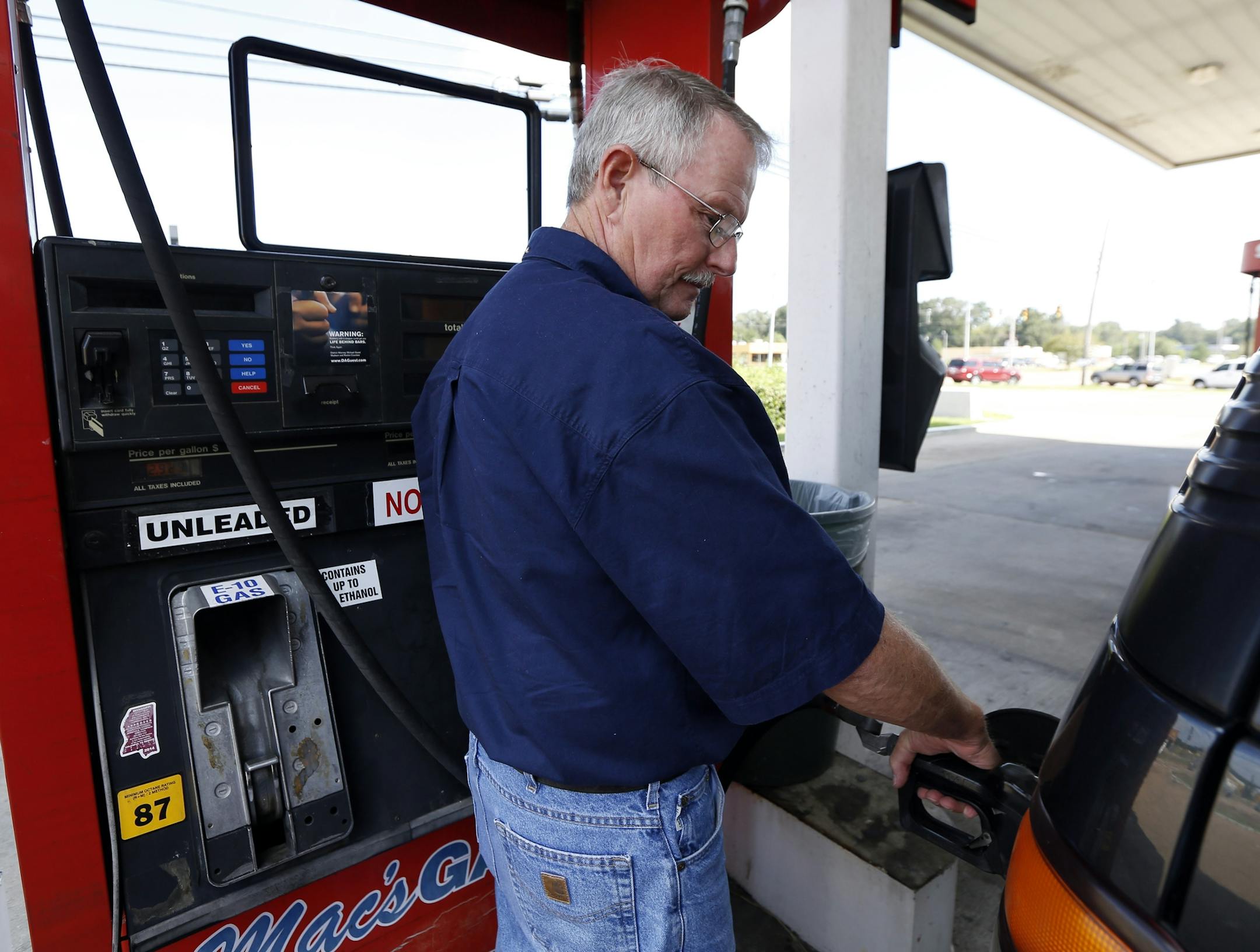 In this Wednesday, Sept. 24, 2014 photo, Foster Gilley, of Chatom, Ala., fills his SUV's tank with $2.92-per-gallon regular gas at Mac's Gas in Richland, Miss. The typical autumn decline in gasoline prices is getting a big push lower by falling global oil prices. By the end of the year, up to 30 states could have an average gasoline price of under $3 a gallon. Gilley and his wife were visiting his brother in Vicksburg and were "enjoying the lower prices," he said. (AP Photo/Rogelio V. Solis)