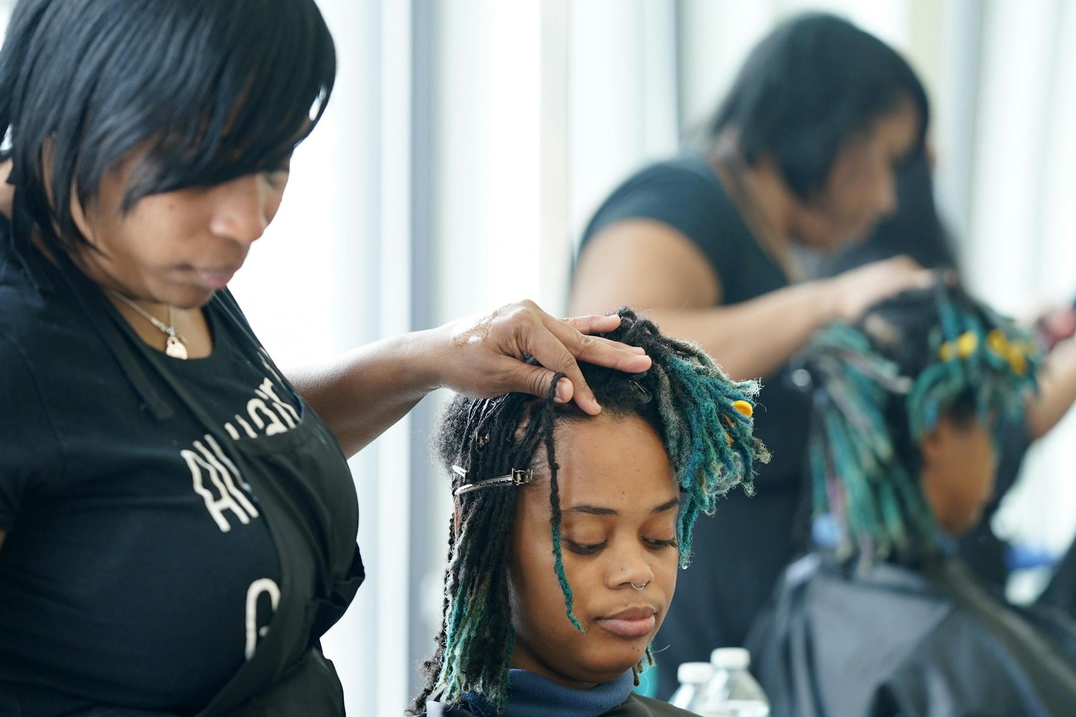 Stylist Erika Carter worked on AK Wright's hair Wednesday morning at the Beauty Lounge.