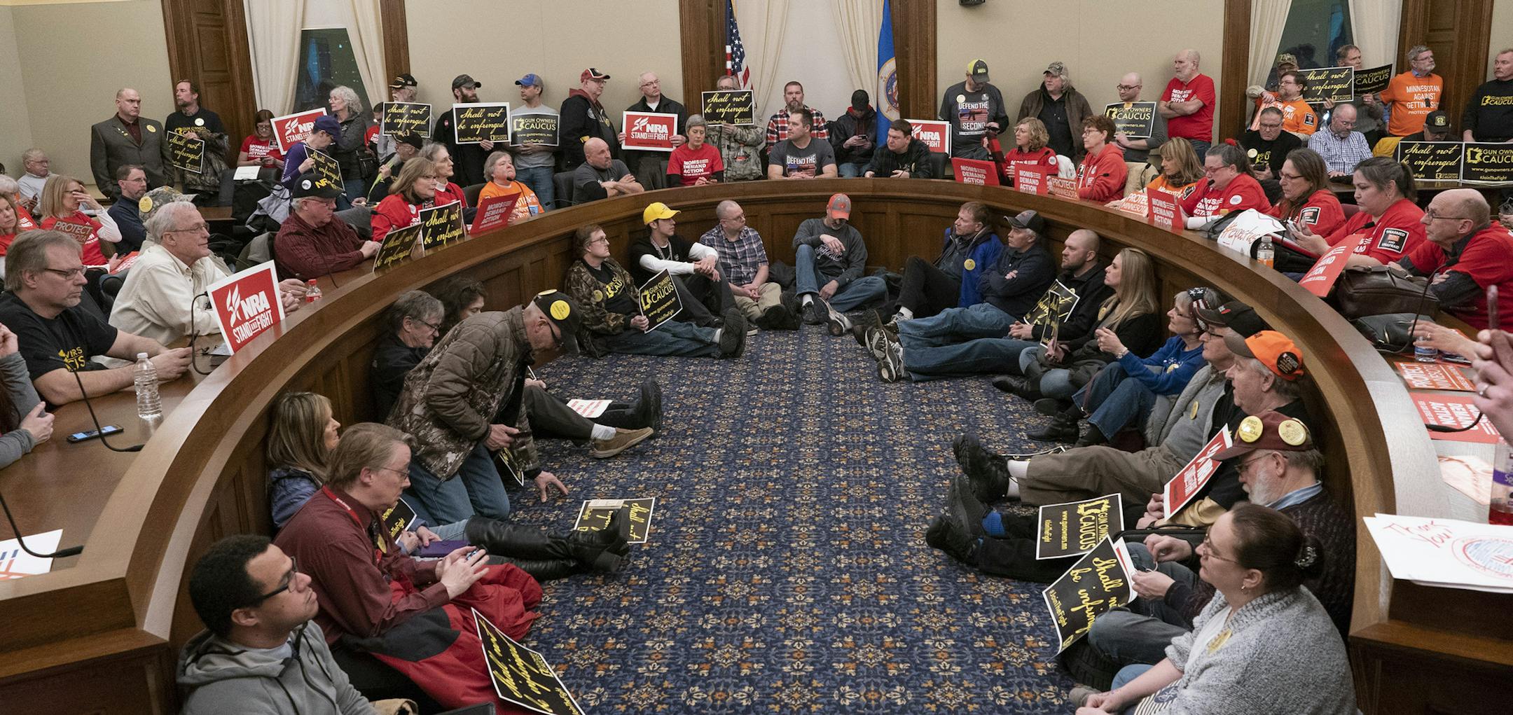 The overflow room was full as supporters on both sides listened as the House public safety committee talked about two bills that would expand background checks and adopt a "red flag" law at the State Capitol Wednesday, Feb. 27, 2019, in St. Paul, Minn. The Minnesota House committee has voted to require universal criminal background checks for gun purchasers. (Jerry Holt/Star Tribune via AP)